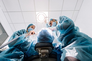 dentist performing surgery representing how dental implants work in Peabody