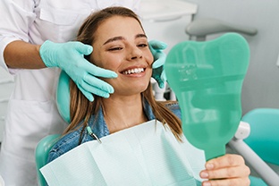 patient smiling while getting a dental crown 