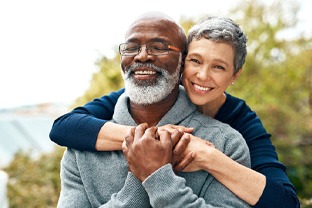 a mature couple smiling with dentures in Peabody