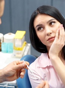 woman in pink shirt seeing emergency dentist in Peabody 