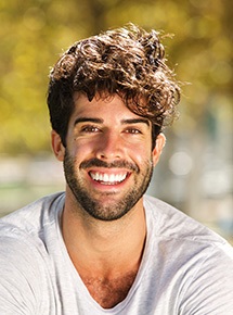 A closeup of a smiling, bearded man