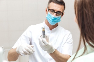 Dentist holding dental implant