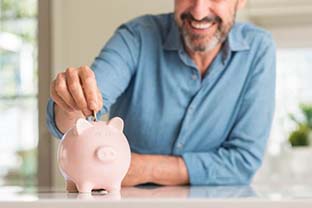 man putting coins into a piggy bank