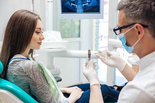 dentist showing a dental implant to a patient