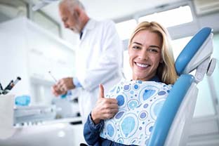 woman giving a thumbs up in the dental chair