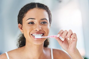 a woman brushing her teeth at home