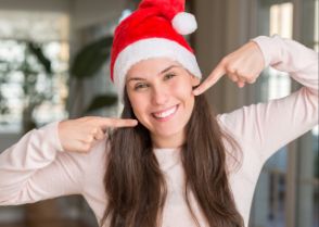 A smiling woman wearing a Santa hat