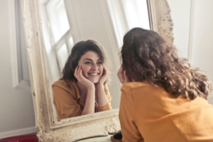 Woman looking in mirror at her teeth