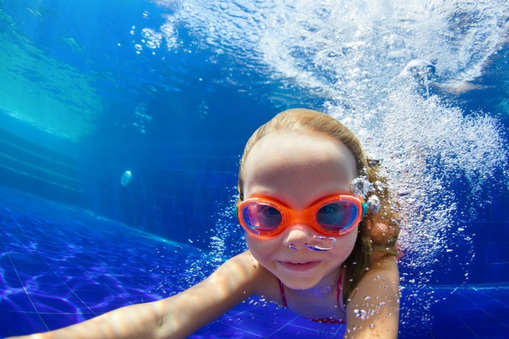 Young child swimming in a pool.