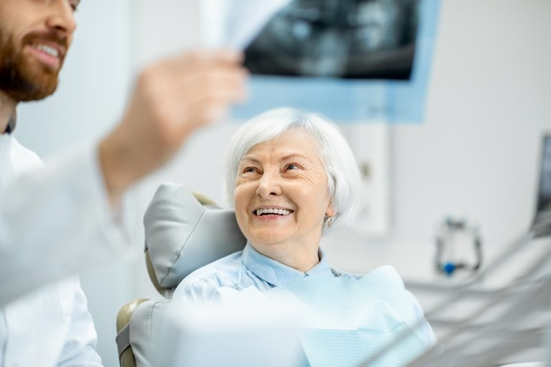 dentist showing X-rays to senior patient 