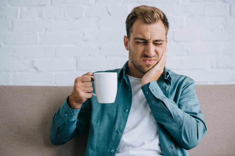 A man holding his jaw due to toothache