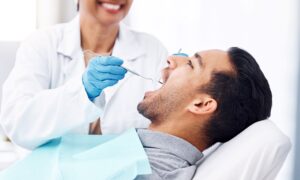 Man with brown hair in gray shirt having dental exam
