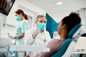 A dentist and his dental assistant get ready to start a patient’s crown treatment