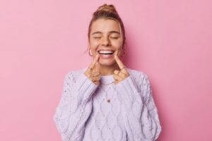 Woman smiling and pointing to her teeth