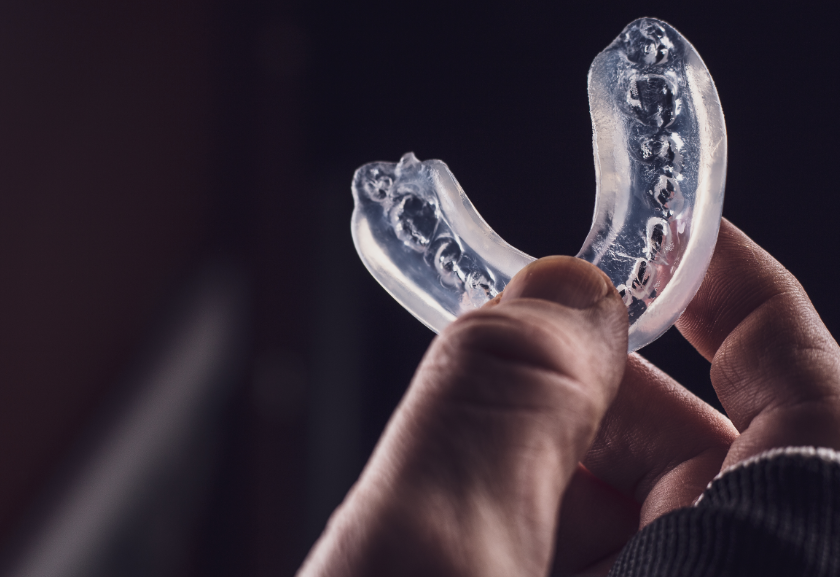 Close up of hand holding a mouthguard